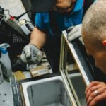 Two technicians diagnosing a faulty refrigeration unit